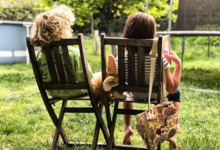 Kids In Backyard - two children sitting on chairs